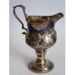 An 18th century helmet-shaped hallmarked silver cream jug;