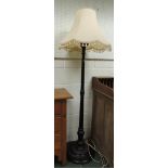 A 20th century ebonised standard lamp with carved laurel leaf decoration to the base, 144cm high.