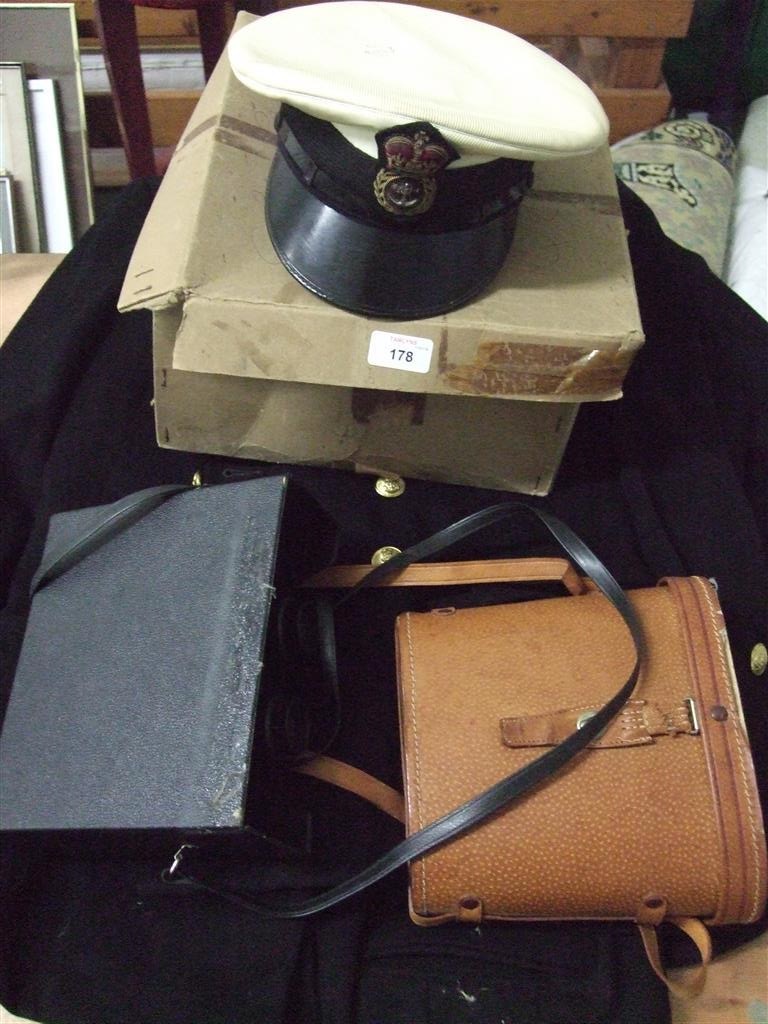 Two naval uniforms together with two naval hats and two cased pairs of binoculars.