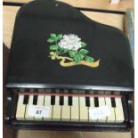 A toy piano with floral decoration.