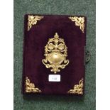 An empty decorative photograph album with velvet and gilt decoration to the cover.