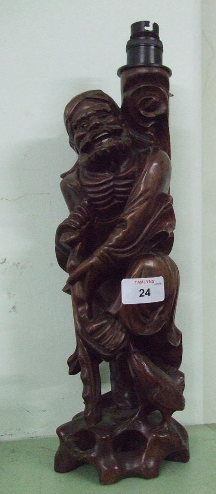 A carved wooden lamp base of a man.