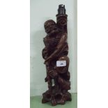 A carved wooden lamp base of a man.