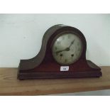 A wooden cased mantle clock with decoration to base.