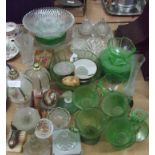 Green glass teacups and plates together with clear glass and other items.