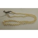 A single strand of freshwater pearls with white metal clasp set with three small diamonds.