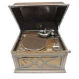 A HMV table top gramophone in oak case with domed top, original winder and reproducer, 47.5cms wide