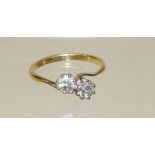 An 18ct gold two stone diamond cross-over ring, each diamond just under half a carat, size S.