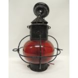 A 19th Century ships light with red glass bowl shade in black painted metal frame and with