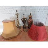 A red, gold and green patterned lamp base, three other lamp bases and two lamp shades.