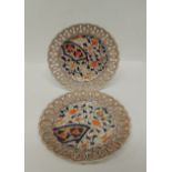 A pair of late 19th Century Japanese Arita Imari plates with pierced rims and painted with floral