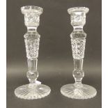 A pair of late Victorian heavy cut glass candlesticks on shaped circular bases with star cut