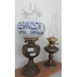 An oil lamp with decorative white opaque glass and blue cover and other oil lamp.