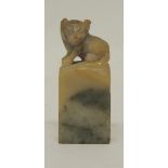 A small Chinese soapstone seal, the finial worked with a cat, the base un-worked, 4.5cms high