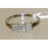 An 18ct white gold large size ring, set with three panels of four square cut diamonds, size W