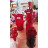 A heavy cut glass ship's decanter, another cut glass decanter, a claret jug and items of red glass.