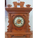 A carved wood cased mantel clock.