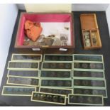 A wood box (lacking lid) containing assorted coins, magic lantern slides, etc.