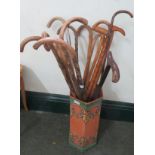 A painted terracotta stick with a quantity of walking sticks.