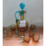 A pretty yellow and blue glass jug and set of seven cups.