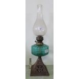 Am oil lamp with decorative metal base and green glass oil container.