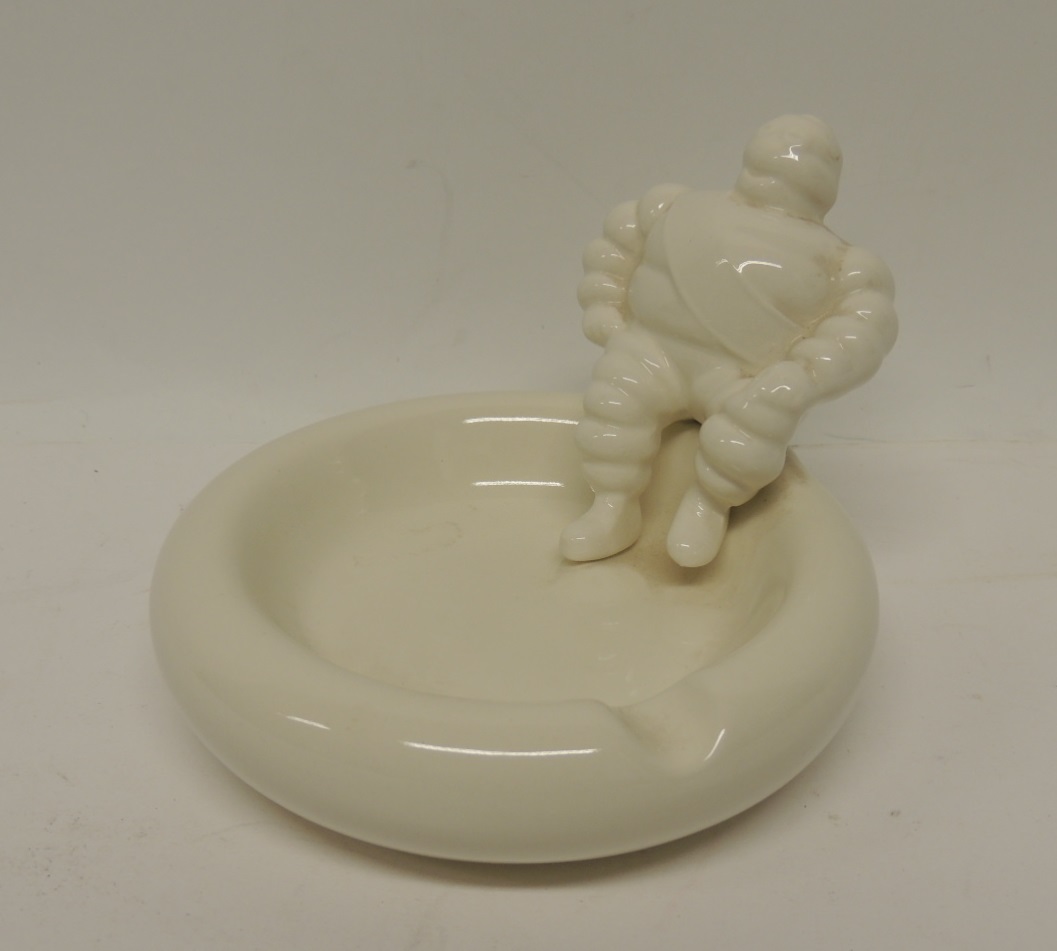 A Michelin promotional glazed pottery ashtray with figure of Michelin Man seated to one side, 9cms