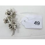 A white gold floral spray brooch, set with diamonds and white sapphires, stamped 585.