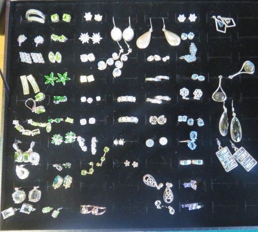 A case of over forty gem set earrings to include moonstone, abalone, peridot, opal etc, all on white