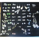 A case of over forty gem set earrings to include moonstone, abalone, peridot, opal etc, all on white