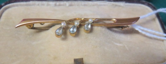 An original cased marked 9ct gold bar brooch, set with three seed pearls and tear drop blue stones