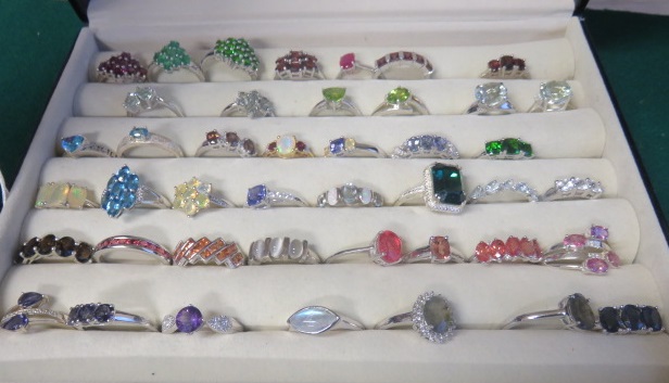 A boxed collection of over forty, mostly marked 925, gem set rings to include ruby, sapphire,