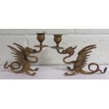 Pair of brass table candelabra in the form of whinged dragons supporting a single candle sconce,