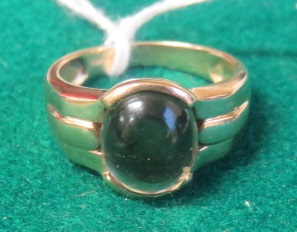 A marked 375 gold ring set with a large oval cabochon of smoky quartz, ring size T, weight 6.5g