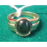 A marked 375 gold ring set with a large oval cabochon of smoky quartz, ring size T, weight 6.5g