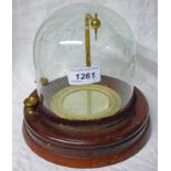 AN ELECTRO MAGNETIC DIAL BY GRYSON LONDON WITH A GLASS DOME AND MAHOGANY BASE,