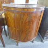 EARLY 20TH CENTURY MAHOGANY DEMI LUNE SIDE CABINET WITH 3 PANEL DOORS ON SHAPED SUPPORTS