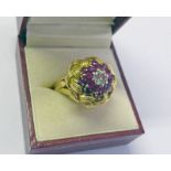 RUBY & DIAMOND BOMBE CLUSTER RING IN A DECORATIVE YELLOW METAL MOUNT, THE CENTRAL DIAMOND APPROX 0.