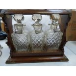 OAK CASED TANTALUS WITH METAL MOUNTS AND THREE DECANTERS Condition Report: not