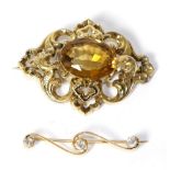 A Victorian citrine brooch, an oval cut citrine in a scroll frame, measures 4cm by 5.2cm, in a