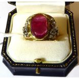 An 18 carat two colour gold glass filled cabochon ruby ring, oval cut in a rubbed over settings,