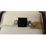 A sapphire and diamond three stone ring, a square cut sapphire spaced by two round brilliant cut