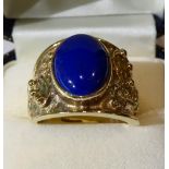 A 9 carat gold lapis lazuli ring, an oval cabochon lapis lazuli in a rubbed over setting, to a
