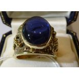 A 9 carat gold glass filled cabochon sapphire ring, oval cut in a rubbed over settings, to a