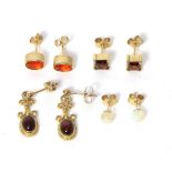 A pair of 9 carat gold oval fire opal stud earrings, a pair of 9 carat gold square cut garnet stud