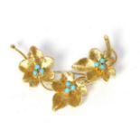 An 18 carat gold turquoise spray brooch, three textured flower heads each set with three