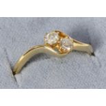An 18 carat gold old cut diamond three stone ring, with bypass shoulders, total estimated diamond