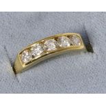 An 18 carat gold diamond half hoop ring, five round brilliant cut diamonds in a channel setting,