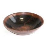 A Winchcombe pottery stoneware bowl, tenmoku iron glaze, impressed seal mark, bears paper label