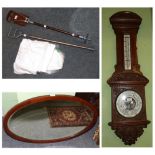 An Edwardian mahogany framed oval mirror; an early 20th century carved walnut barometer, John Davies