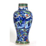 A Chinese Porcelain Baluster Vase, Kangxi, painted in underglaze blue and clobbered with panels of